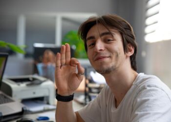 çoklu görev yaparken dizüstü bilgisayarda çalışan kişi