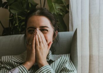 İkincil utanç hisseden ve yüzünü eliyle kapatan genç bir kişi