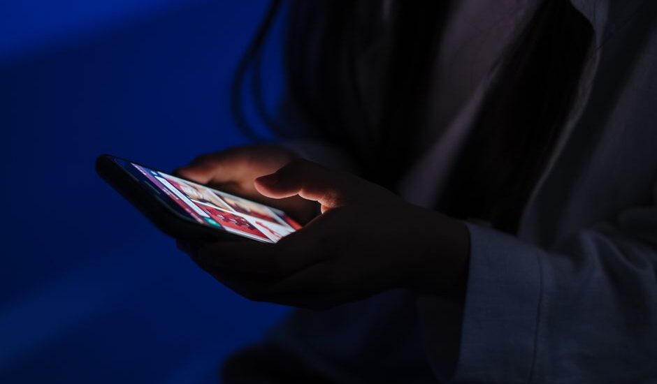 Ekran bağımlılığı yaşayan bir kişi telefonuna bakıyor